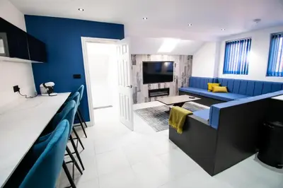 a living room with blue walls and a blue couch at Winter Gardens Suites by Sasco in Blackpool