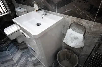 a bathroom with a white sink and a toilet at Winter Gardens Suites by Sasco in Blackpool