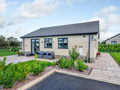 a house with a patio and a garden at Mya Cottage in Wilpshire