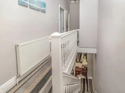 a white hallway with a staircase with white railings at Edenfield Number 42 in Blackpool