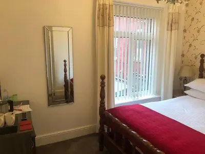 a bedroom with a bed and a window with a mirror at Edenfield Number 42 in Blackpool