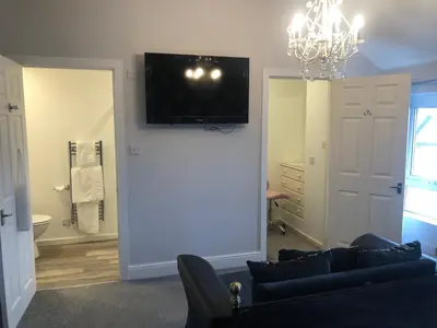 a living room with a couch and a television on a wall at Edenfield Number 42 in Blackpool