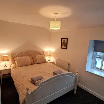 a bedroom with a large bed and a window at Town Centre Maisonette in Ulverston