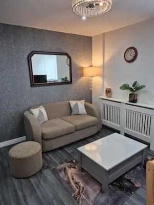 a living room with a couch and a table at Town Centre Maisonette in Ulverston