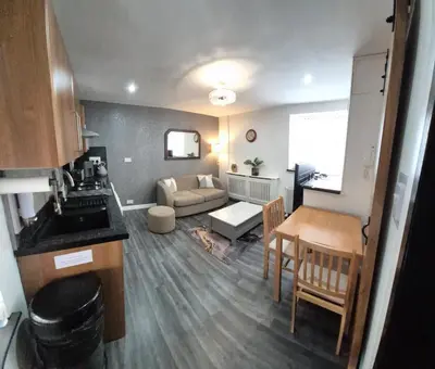 a kitchen and living room with a table and a couch at Town Centre Maisonette in Ulverston