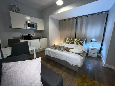 a bedroom with a bed and a living room at Moorfield Liverpool City Studios in Liverpool
