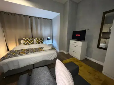 a bedroom with a bed and a tv and a couch at Moorfield Liverpool City Studios in Liverpool