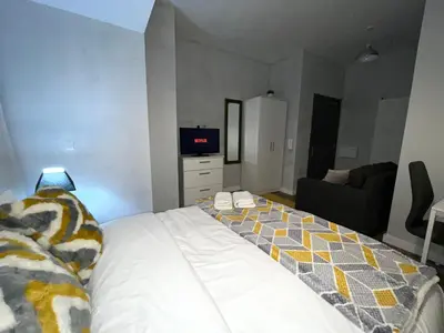 a bedroom with a bed and a couch and a tv at Moorfield Liverpool City Studios in Liverpool