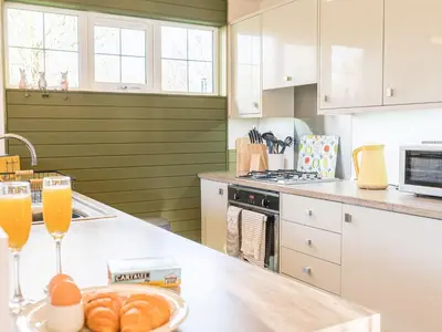 a kitchen with a counter with two glasses of orange juice at Fern Lodge in Grange Over Sands