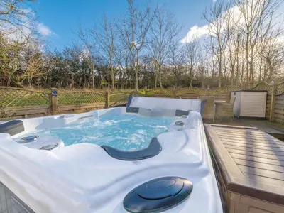 a large hot tub sitting on a deck at Fern Lodge in Grange Over Sands
