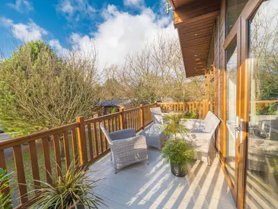a deck with chairs and plants on a house at Fern Lodge in Grange Over Sands