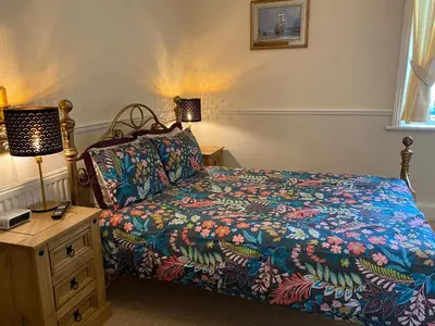 a bedroom with a bed with a colorful comforter at The Laurels in Blackpool