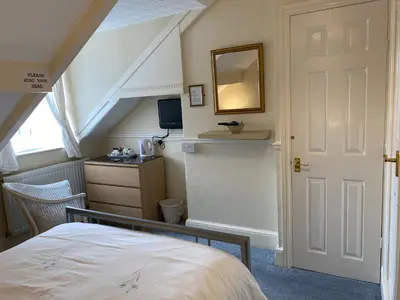 a bedroom with a bed and a mirror on the wall at The Laurels in Blackpool