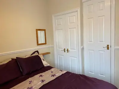 a bedroom with a bed with purple sheets and a door at The Laurels in Blackpool