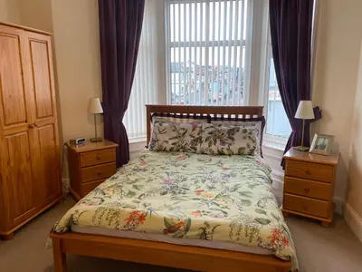 a bedroom with a bed and a large window at The Laurels in Blackpool
