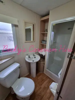 a bathroom with a toilet and a sink and a shower at Becky's Caravan at Marton Mere in Blackpool