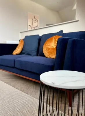 a blue couch and a white table in a living room at The Apartments Lytham Square in Lytham St Annes
