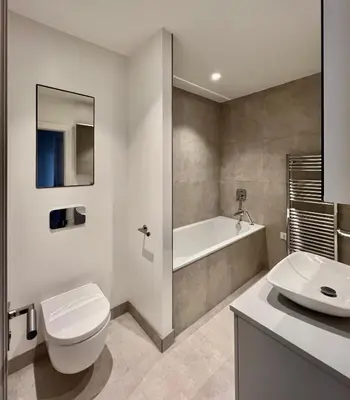 a bathroom with a toilet and a tub and a sink at The Apartments Lytham Square in Lytham St Annes