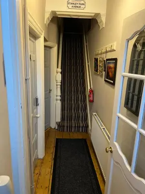 a hallway with a stairway with a black rug at Rooms Anfield- 5 mins from LFC in Liverpool