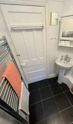 a small bathroom with a sink and a bed at Rooms Anfield- 5 mins from LFC in Liverpool