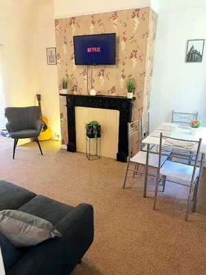 a living room with a tv above a fireplace at Rooms Anfield- 5 mins from LFC in Liverpool