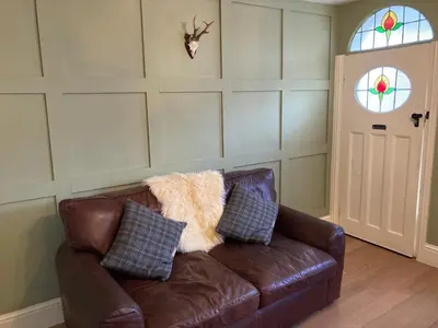 a brown leather couch with pillows in a living room at Adlington Cottage, Lancashire in Adlington