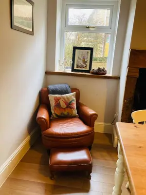 a brown chair in a room with a window at Adlington Cottage, Lancashire in Adlington