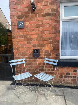two chairs sitting in front of a brick building at Adlington Cottage, Lancashire in Adlington