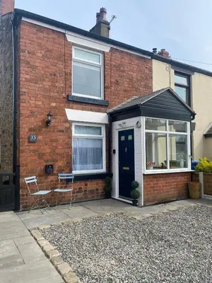 a brick house with a blue door and windows at Adlington Cottage, Lancashire in Adlington