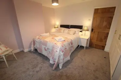 a bedroom with a bed and a wooden door at Adlington Cottage, Lancashire in Adlington