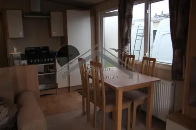 a kitchen and dining room with a table and chairs at Tranquility - Static Caravan Lune Park on Parkdean Ocean Edge Resort in Heysham