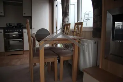 a glass table and chairs in a kitchen at Tranquility - Static Caravan Lune Park on Parkdean Ocean Edge Resort in Heysham