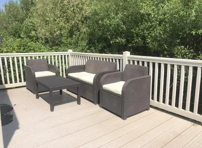 two wicker chairs and a table on a deck at Tranquility - Static Caravan Lune Park on Parkdean Ocean Edge Resort in Heysham