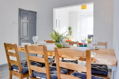 a dining room with a wooden table and chairs at Cosy 3 bedroom house near Anfield Stadium in Liverpool