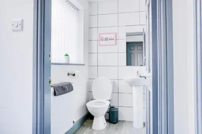 a white bathroom with a toilet and a sink at Cosy 3 bedroom house near Anfield Stadium in Liverpool