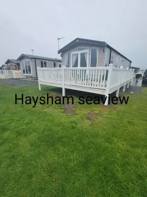 a house with a large white porch and a yard at Heysham seaview in Heysham