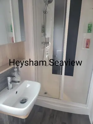 a bathroom with a white sink and a shower at Heysham seaview in Heysham