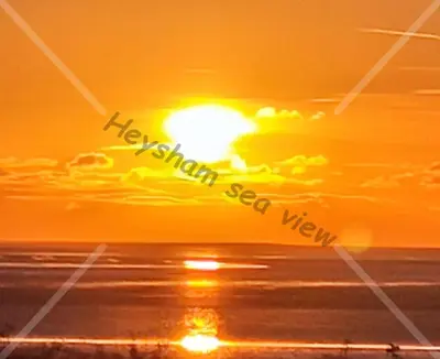 a sunset over the ocean with the sun in the sky at Heysham seaview in Heysham