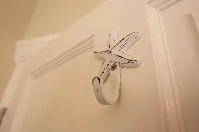 a white cross hanging on a wall next to a door at Mulberry Cottage - Cosy 3 Bed Cottage near Lytham Windmill in Lytham St Annes