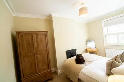a bedroom with a bed with a backpack sitting on it at Mulberry Cottage - Cosy 3 Bed Cottage near Lytham Windmill in Lytham St Annes