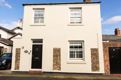 a white house with a black door and windows at Mulberry Cottage - Cosy 3 Bed Cottage near Lytham Windmill in Lytham St Annes
