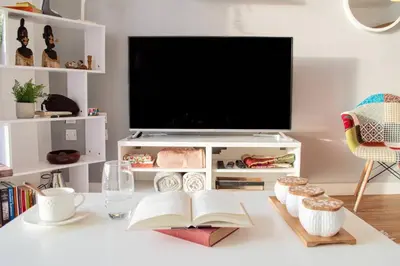 a living room with a tv and a book on a table at Stunning Mersey View Flat w Parking in Liverpool in Liverpool