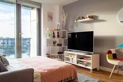 a living room with a flat screen tv and a couch at Stunning Mersey View Flat w Parking in Liverpool in Liverpool