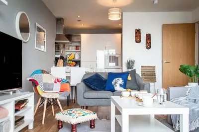 a living room with a couch and a table at Stunning Mersey View Flat w Parking in Liverpool in Liverpool