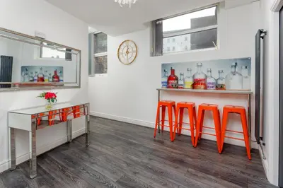 a bar with orange stools in a room at Snuggle Cove Apartments By Bella Vita Stays in Liverpool