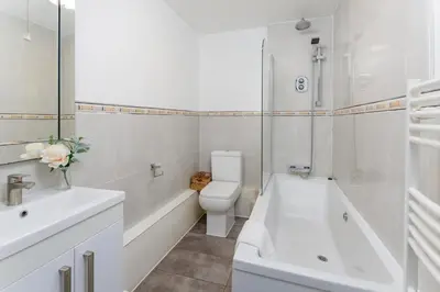 a white bathroom with a toilet and a tub and a sink at Snuggle Cove Apartments By Bella Vita Stays in Liverpool