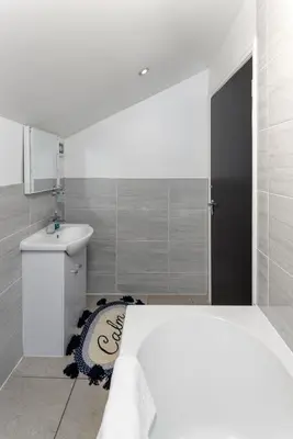 a white bathroom with a bed and a sink at Snuggle Cove Apartments By Bella Vita Stays in Liverpool