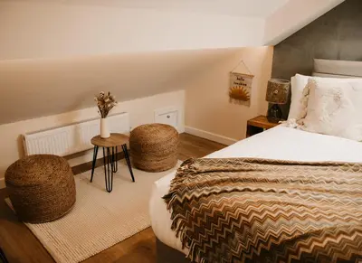 a bedroom with a bed and a table with a vase on it at The Old Brewery in Ulverston