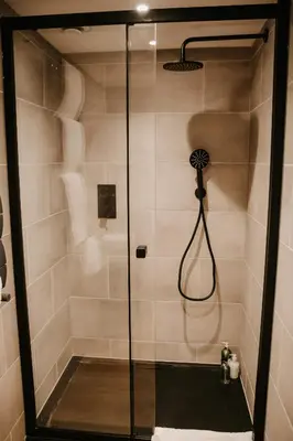 a shower with a glass door in a bathroom at The Old Brewery in Ulverston