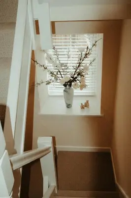 a staircase with a vase with flowers in a window at The Old Brewery in Ulverston